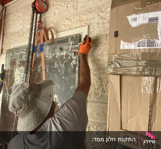 אדם עובד על קיר עם כלי עבודה ושרשרת
